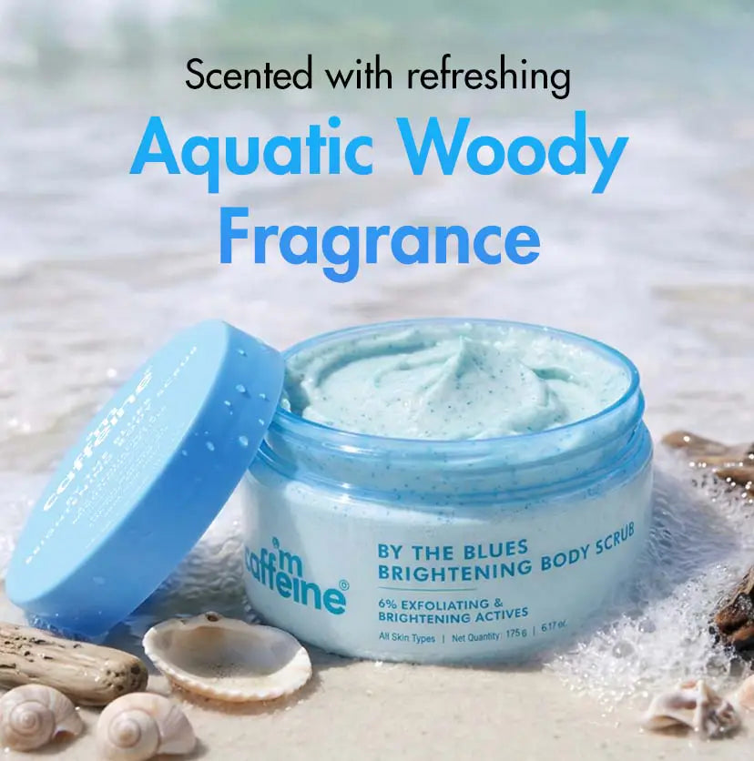mCaffeine By The Blues Brightening Body Scrub 175 g - aquatic woody fragrance visual with the open tub on sand and shells
